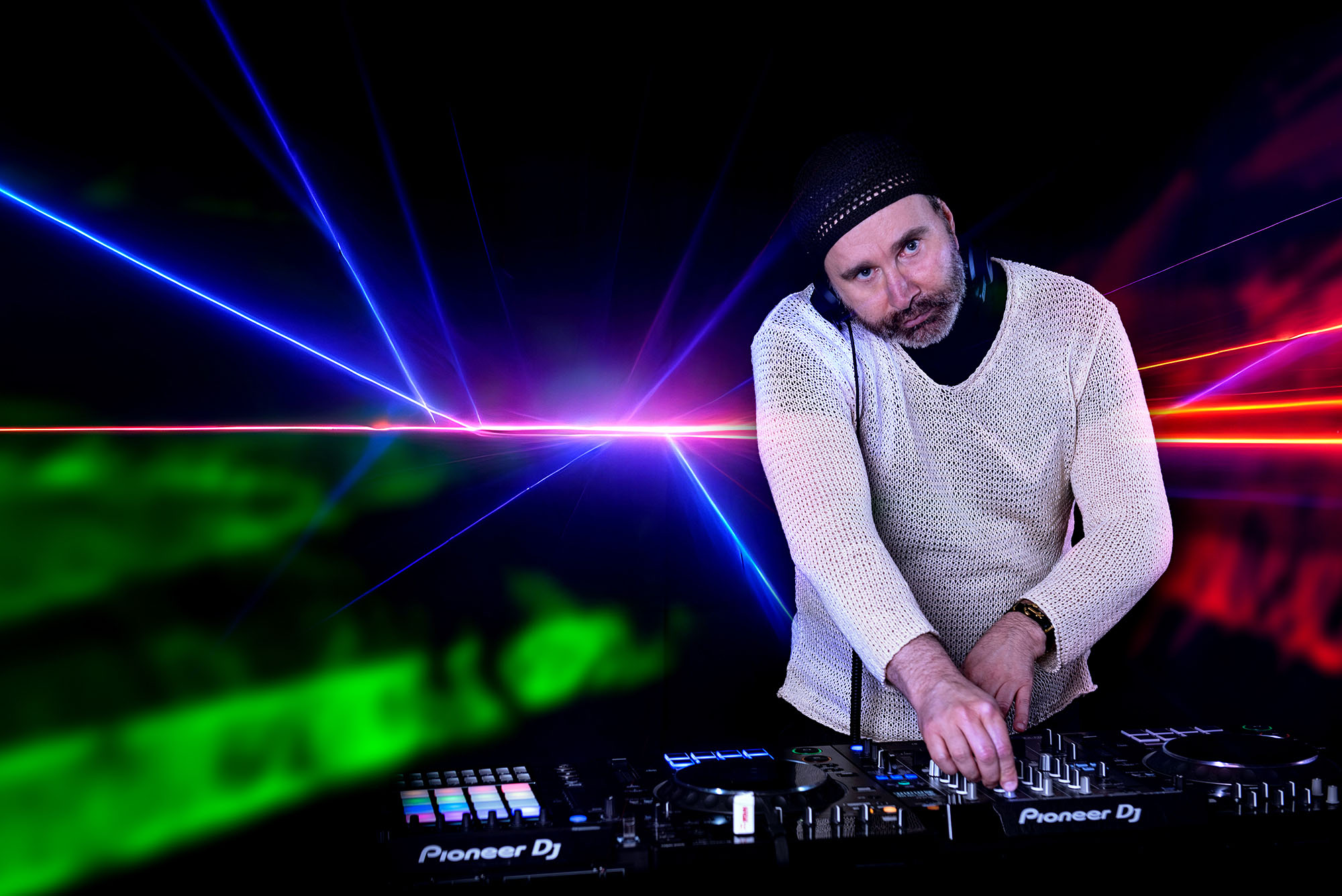 ritratto professionale di un dj in studio con luci laser colorate proiettate sullo sfondo, book fotografico per artisti e musicisti